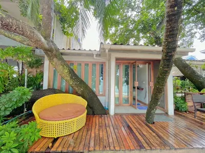 a porch with a yellow chair on a wooden deck at Palm Resort Krabi in Ban Ko Kwang