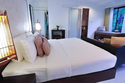a bedroom with a large white bed with pillows at Palm Resort Krabi in Ban Ko Kwang