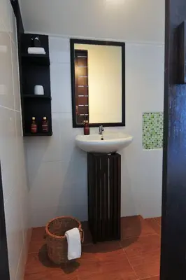 a bathroom with a sink and a mirror and a basket at Palm Resort Krabi in Ban Ko Kwang