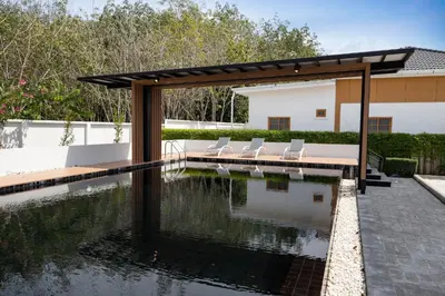 a swimming pool with chairs and a pavilion over it at Villa Sunrise Garden A181 in Thalang