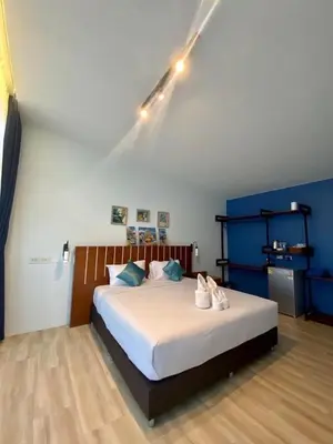 a bedroom with a large bed with shoes on it at Blue Ba You Resort in Ban Khlong Haeng