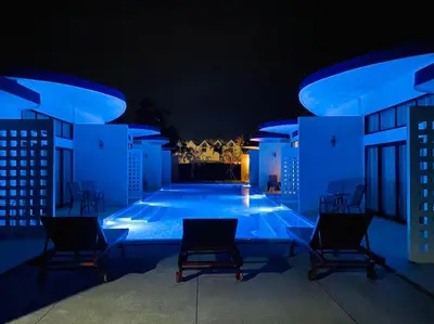 a swimming pool at night with blue lights at Blue Ba You Resort in Ban Khlong Haeng