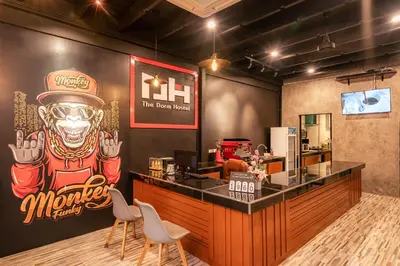 a restaurant with a bar with a monkey sign on the wall at The Dorm Hostel in Ban Lo Long