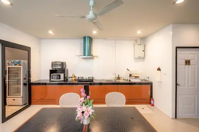 a kitchen with a table with a vase of flowers on it at The Dorm Hostel in Ban Lo Long