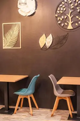 a restaurant with two chairs and a wall with clocks at The Dorm Hostel in Ban Lo Long