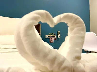 a pair of swans forming a heart on a bed at THE NICE in Patong Beach