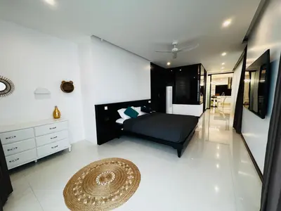a bedroom with a black bed and a rug at Sunrise Ocean Villa 20 in Phuket Town