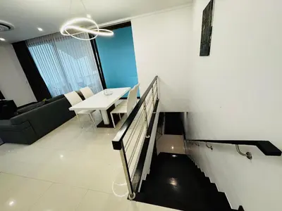 a living room with a staircase and a table and a couch at Sunrise Ocean Villa 20 in Phuket Town
