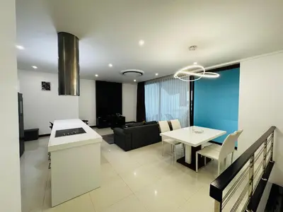 a kitchen and a living room with a table at Sunrise Ocean Villa 20 in Phuket Town