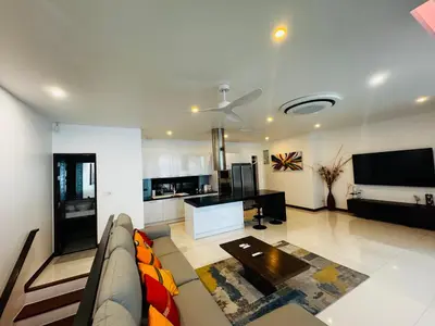 a living room with a couch and a table at The Sunrise Ocean Villa 22 in Phuket Town