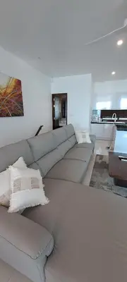 a white living room with a large white couch at The Sunrise Ocean Villa 22 in Phuket Town