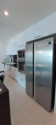 a stainless steel refrigerator in a kitchen with white cabinets at The Sunrise Ocean Villa 22 in Phuket Town