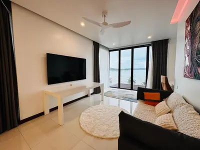 a living room with a flat screen tv on a wall at The Sunrise Ocean Villa 22 in Phuket Town