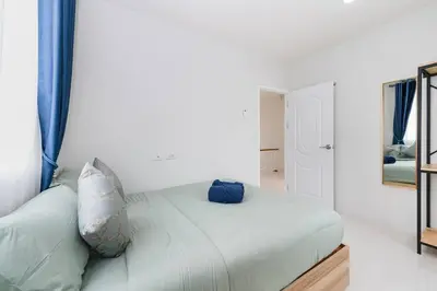 a white bed with two pillows on it in a room at Phuket's unique Sino-style villa with private pool in Ban Bang Khu