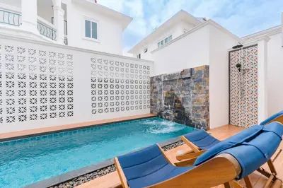 a swimming pool with blue lounge chairs and a house at Phuket's unique Sino-style villa with private pool in Ban Bang Khu