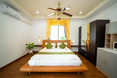 a bedroom with a bed with a ceiling fan at ฺBaan Waru seaview villa in Kata Beach