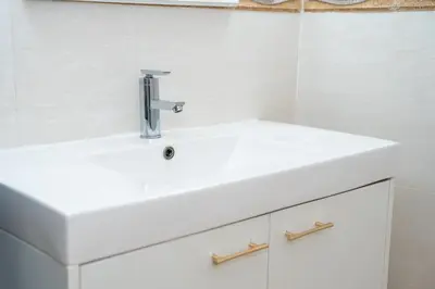 a white bathroom sink with a chrome faucet at ฺBaan Waru seaview villa in Kata Beach