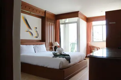 a bedroom with a bed with a teddy bear sitting on it at Talya Patong Hotel in Patong Beach
