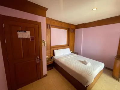 a small bedroom with a bed and a window at Talya Patong Hotel in Patong Beach
