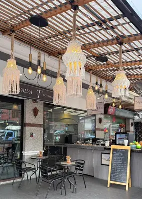 a restaurant with tables and chairs and chandeliers at Talya Patong Hotel in Patong Beach