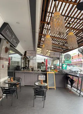 an empty restaurant with tables and chairs and chandeliers at Talya Patong Hotel in Patong Beach