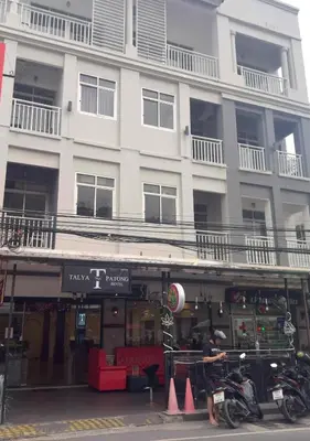 a man on a motorcycle in front of a building at Talya Patong Hotel in Patong Beach