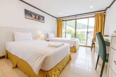 a hotel room with two beds and a balcony at South Siam Hotel in Phuket Town