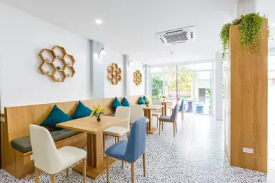 a restaurant with wooden tables and blue chairs at South Siam Hotel in Phuket Town