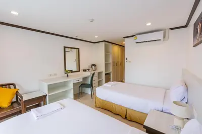 a hotel room with two beds and a desk at South Siam Hotel in Phuket Town