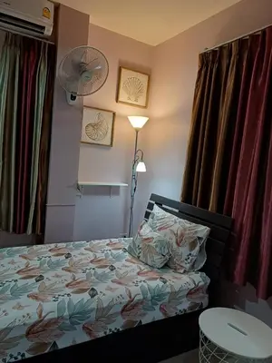 a bedroom with a bed and a lamp and a fan at 168Hostel Airport@Phuket in Thalang