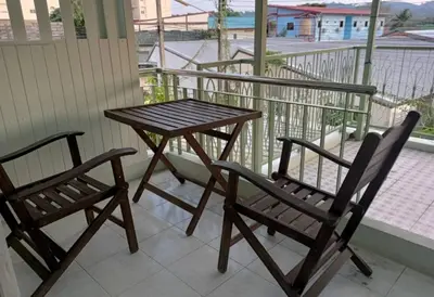 two chairs and a wooden table on a balcony at 168Hostel Airport@Phuket in Thalang