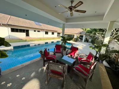 a patio with chairs and a table and a pool at Maya Villa by G Estate in Rawai Beach