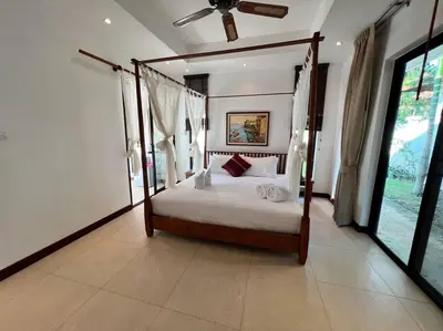 a bedroom with a canopy bed and a large window at Maya Villa by G Estate in Rawai Beach