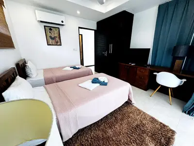 a hotel room with two beds and a television at Seaview Prima Villa Karon beach in Karon Beach