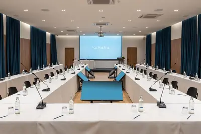 a conference room with tables and chairs and a screen at VARANA Krabi Hotel in Klong Muang Beach