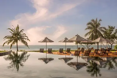 a pool with chairs and umbrellas on the beach at Anantara Koh Yao Yai Resort & Villas in Ko Yao Yai