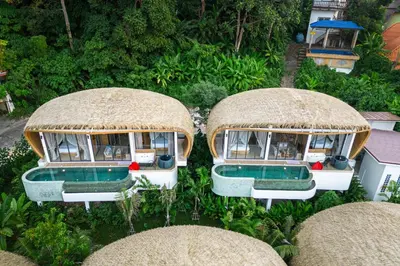 an aerial view of three buildings with grass roofs at Three Monkeys Villas in Patong Beach