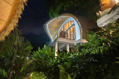 a house with a round window in the middle of plants at Three Monkeys Villas in Patong Beach