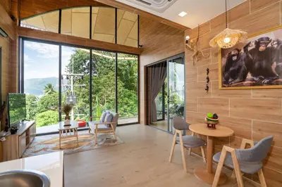a living room with wooden walls and a large window at Three Monkeys Villas in Patong Beach