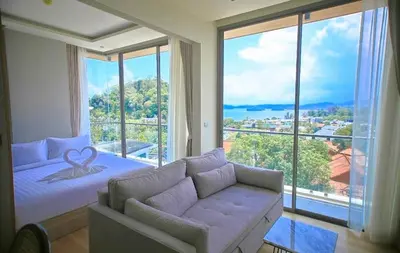 a room with a bed and a couch and a large window at CORNER SEA VIEW KRABI Ao Nang 4 STARS HOTEL RESIDENCE in Ao Nang Beach