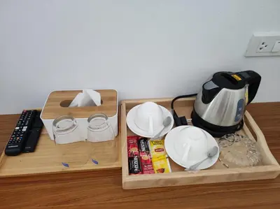 two wooden trays with plates and a tea kettle on a table at PP. Valentine Bungalow in Phi Phi Don