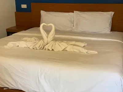a towel animal made to look like two swans on a bed at PP. Valentine Bungalow in Phi Phi Don