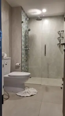 a bathroom with a toilet and a glass shower at Nai Yang Beach Holiday Rental Apartement - Title Residence in Nai Yang Beach