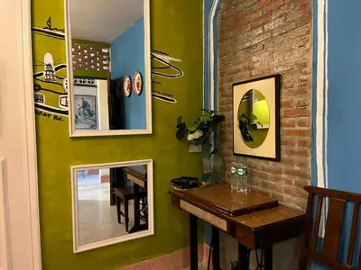 a room with a table and a mirror on the wall at Auntie & Niece PHUKET in Ban Sam Kong