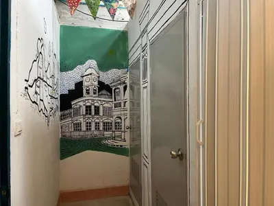 a hallway with a painting of a house on the wall at Auntie & Niece PHUKET in Ban Sam Kong