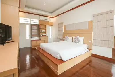 a bedroom with a white bed and a television at Kata Forte Resort in Kata Beach