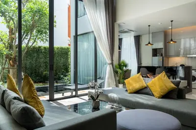 a living room with a couch and a table at Panora villa by VillaCarte in Surin Beach