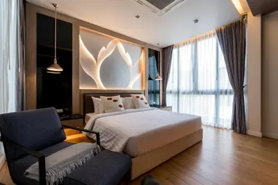 a hotel room with a bed and a chair at Panora villa by VillaCarte in Surin Beach