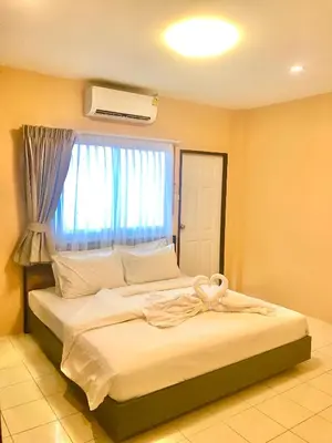 a bedroom with a large bed with a window at The Luka Guesthouse in Patong Beach