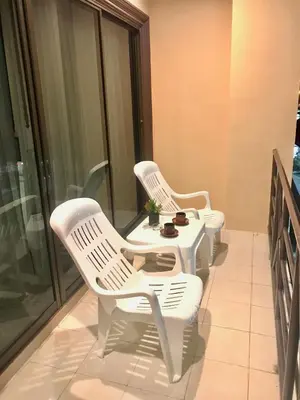 two white chairs and a table on a balcony at The Luka Guesthouse in Patong Beach